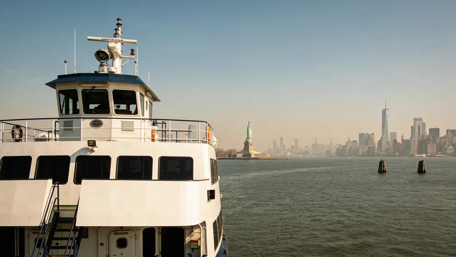 Statue City Cruises ferry boat on New York Harbor with the Statue of Liberty in the distance — how to visit Statue of Liberty by ferry