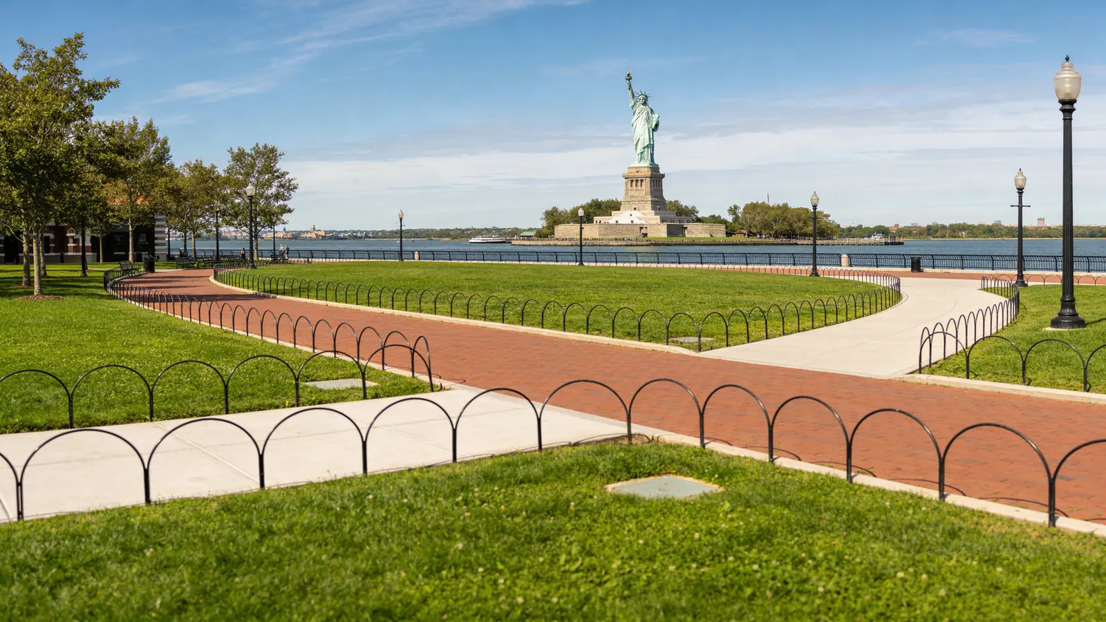 Liberty Island plaza on a clear day with the Statue of Liberty rising in the background — how to visit Statue of Liberty island grounds