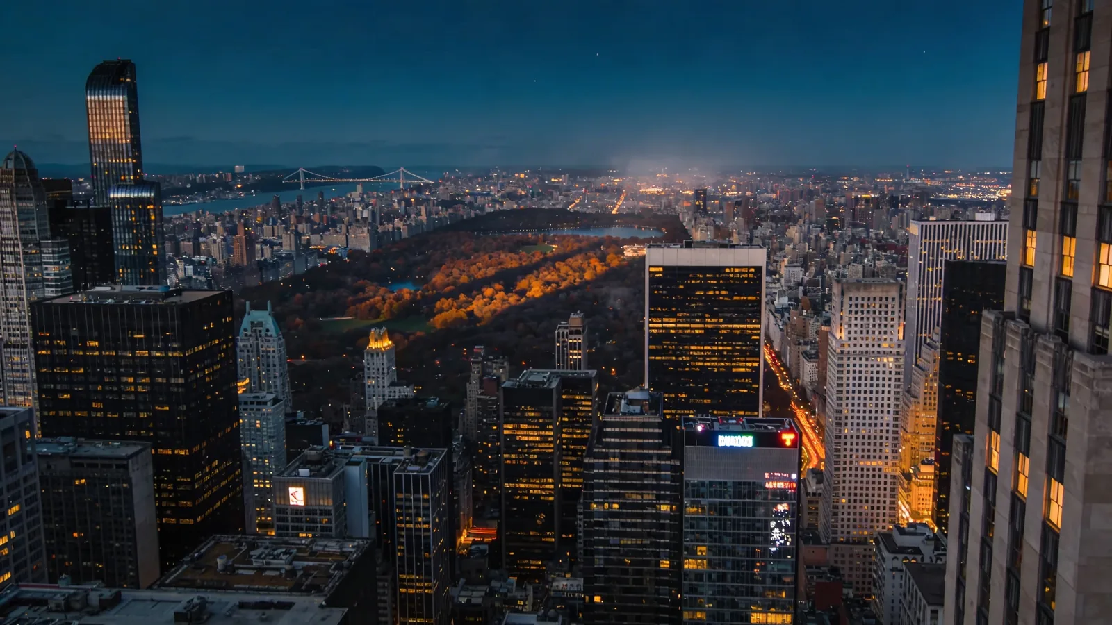 Manhattan skyline at autumn blue hour with city lights and dark Central Park canopy below — Top of the Rock in fall blue hour